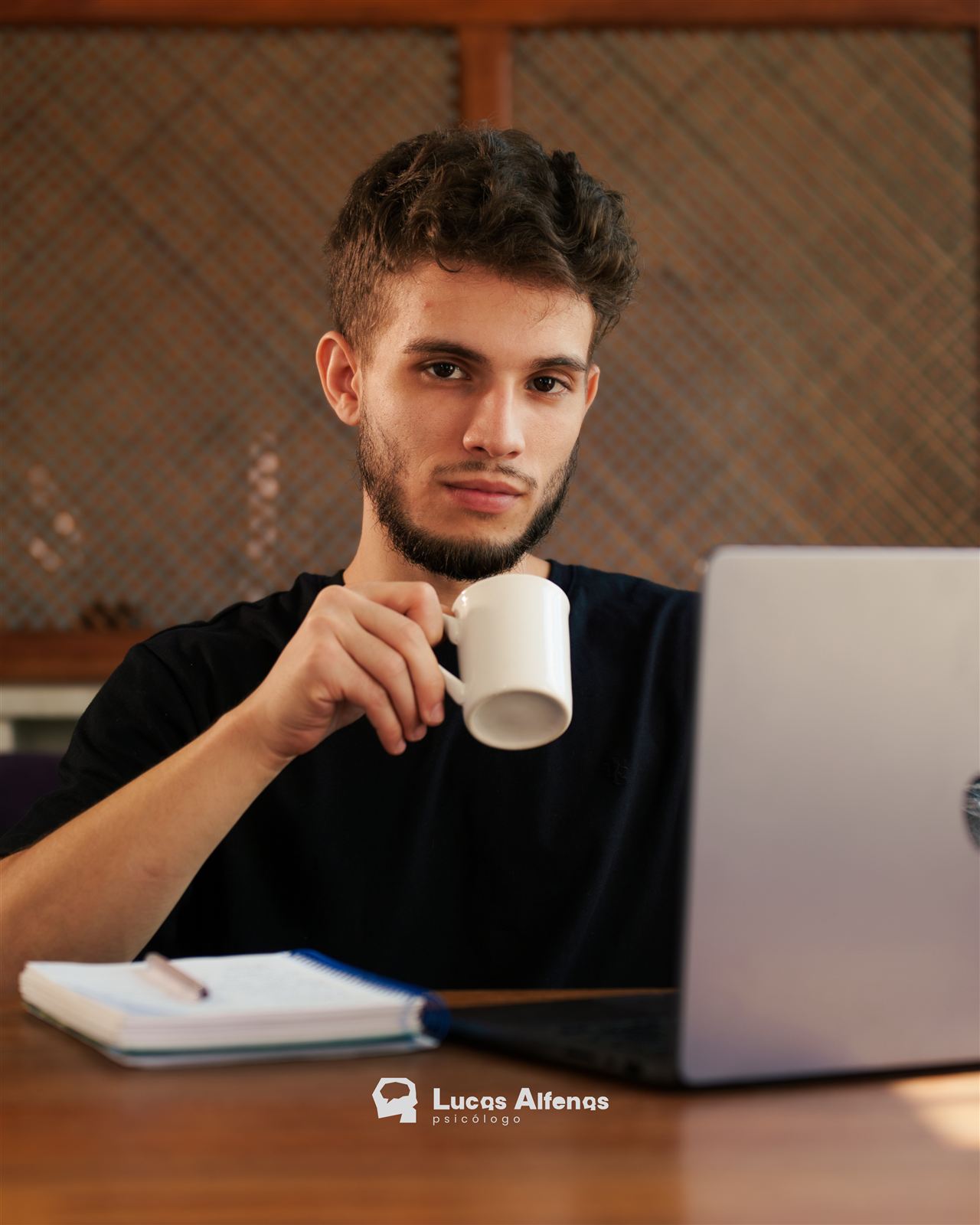 Lucas Alfenas em atendimento online, com café e notebook